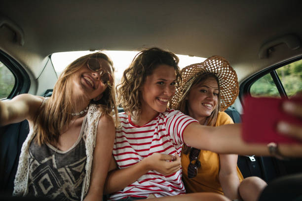Teenage Girls Doing Selfie On Back Seat Of The Car